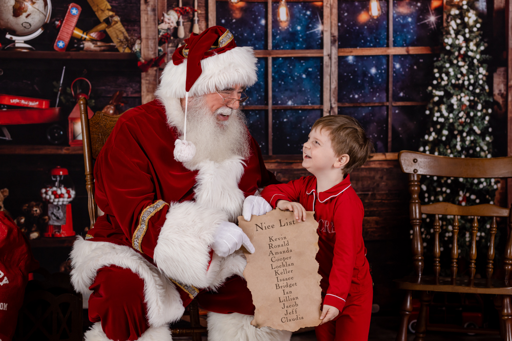 child holding nice list with santa