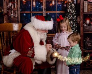 two children interacting with santa during a private christmas photo shoot