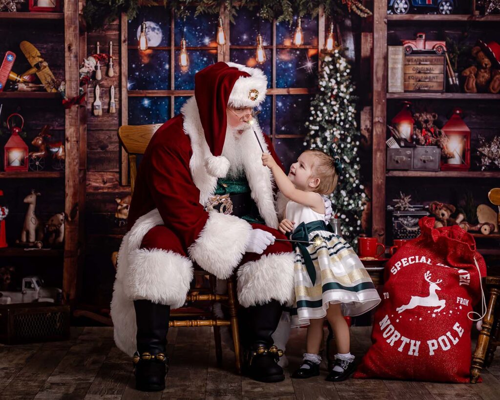 a portrait of little girl painting Santa's nose