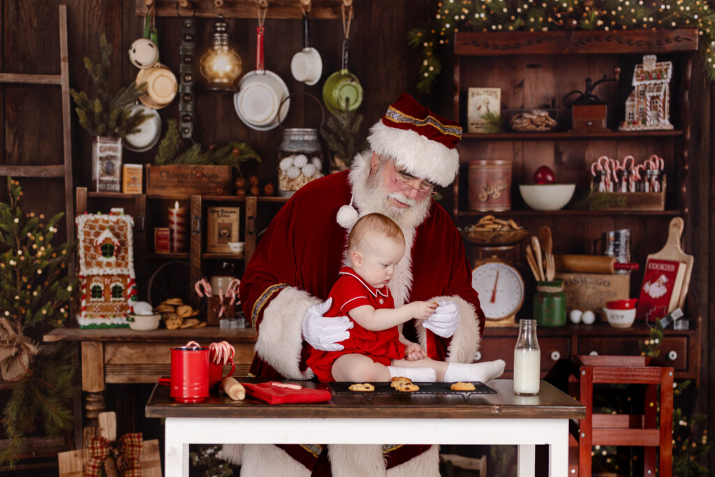 toddle baby being photographed with santa in palm harbor florida in his interactive kitchen play set with real cookies 