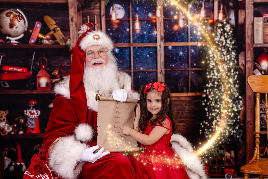 Young girl pointing to santa's nice list in a tampa bay florida photo session with santa claus