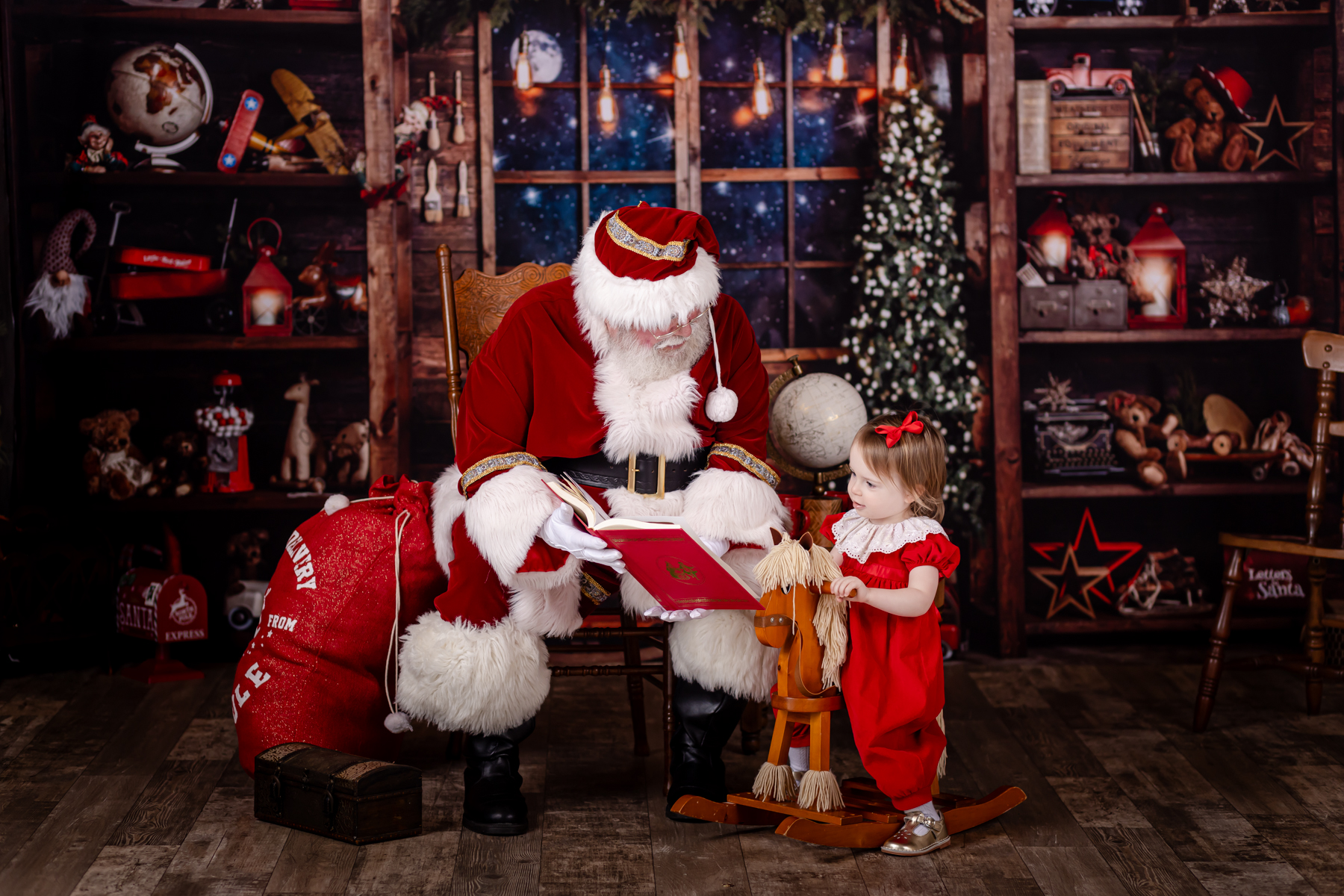toddler girl looking at a book with santa