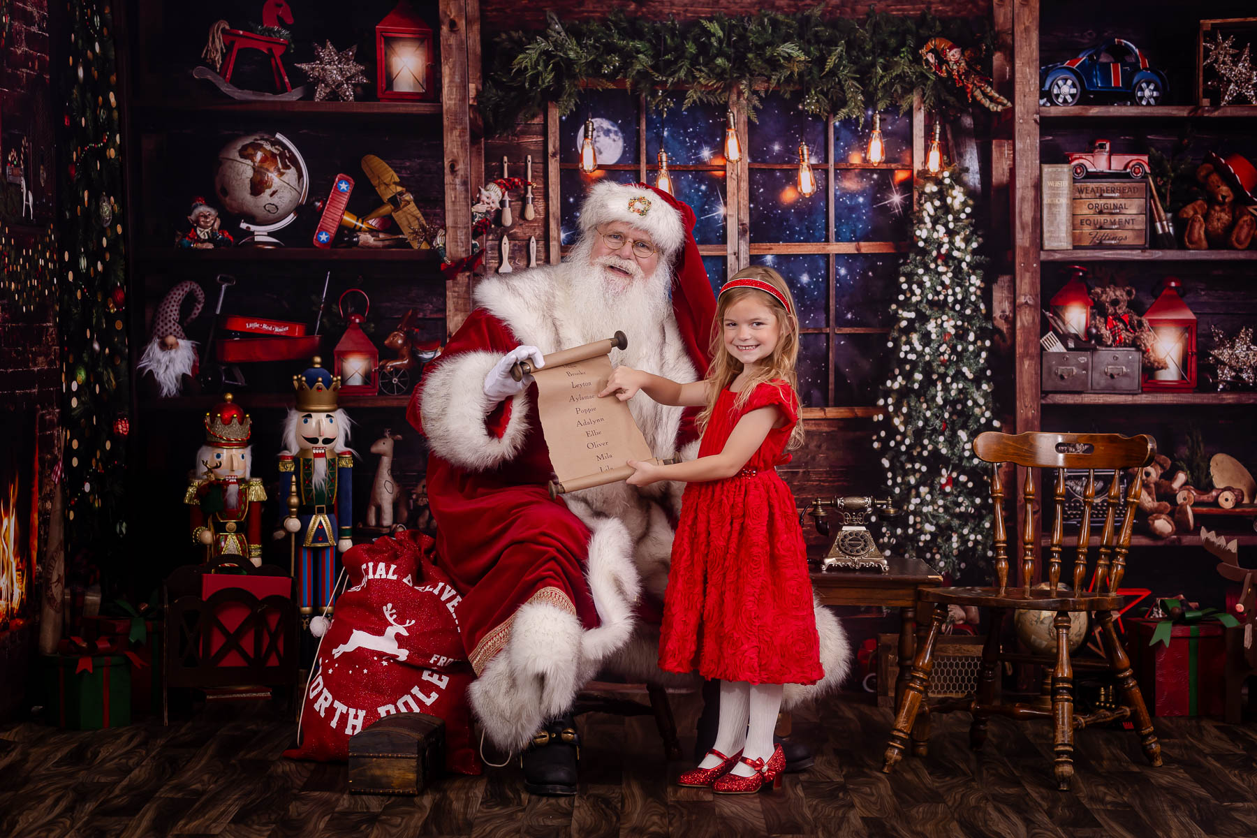 Child smiling with Santa pointing to name on the Nice List during a photo session in Palm Harbor Florida